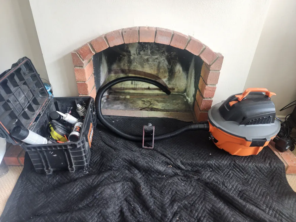 Professional sweeping equipment set up at an arched fireplace